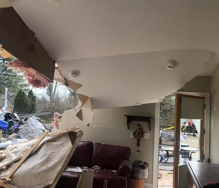 Caved in ceiling and wall after a plane hit the property.